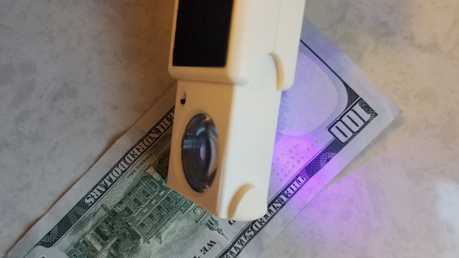 Handheld pocket-sized counterfeit tool with UV type light over money to verify if it's fake or not. Magnifier pulls out of tool and light source can be changed from UV to Bright White LED. Please purchase through National Supply Company LLC.